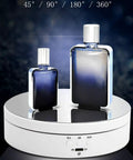 KobeIeen Electric Jewelry Turntable Display With 3 Speed Settings, Battery Powered Rotating Stand For Watches And Cosmetics, Sleek Mirror Finish One Button Control Sturdy Ab Building Perfect Gift Idea showcasing two perfume bottles on the rotating stand.