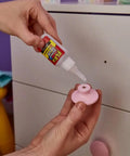 Applying Crystal Clear Super Glue Instant Bond Adhesive Hella Tough 20 Gram Bottle to pink knob for quick home repairs.