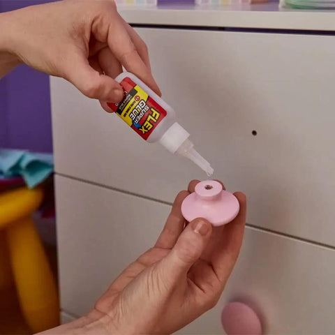 Applying Crystal Clear Super Glue Instant Bond Adhesive Hella Tough 20 Gram Bottle to pink knob for quick home repairs.