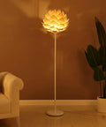 Artichoke Design 68 Inch Tall Free Standing LED Floor Lamp With Multi Panel Wooden Shade For Living Room Ambience A Modern Farmhouse Statement Piece And Slim Tall Pole Lighting With Warm Dimmable Glow in a cozy room corner lighting up a beige wall.
