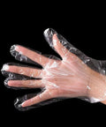 Front view of a hand wearing a clear disposable plastic food-prep glove.