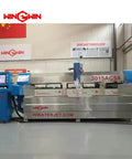 Front view of waterjet cutting machine with blue side consoles and stainless steel body; WIN GWIN branding