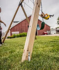 Close-up of installed Playset Anchor Kit For Swing Sets Heavy Duty Ground Anchors on a wooden swing set in a backyard