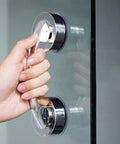 Hand holding strong suction cup handle for glass doors; seamless installation, reusable durable build, 2.5 inch diameter chassis.