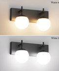 Matte Black Two Light Bathroom Wall Light Fixtures With Milky Glass Globes Sleek Mid Century Modern Vanity Lighting For Bathrooms 14 Inch Long 6.3 Inch Projection G9 Bulb Compatible showing warm and white light.
