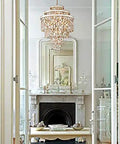 Elegant living room view featuring a chandelier and a fireplace with a polished silver finish, showcasing sharp crystal accents.