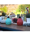 Decorative Glass Table Torch With Durable Fiberglass Wick And Metal Snuffer Creates Cozy Ambience For Dining Or Desk Decor Burns Up To Six Hours Per Fill A Thoughtful Holiday Gift For Family And Friends on an outdoor table.