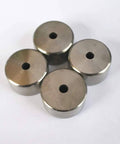 Top view of four stainless steel poppet seats with central holes for water jet spare parts
