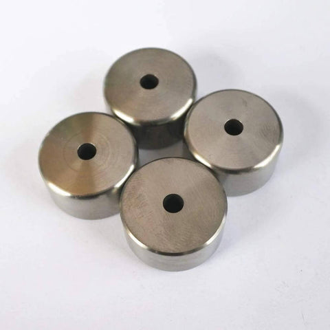 Top view of four stainless steel poppet seats with central holes for water jet spare parts
