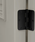 Close-up of a black door hinge installed on a white door, part of 24 Pack Matte Black Door Hinges 3.5 Inch By 3.5 Inch Interior Door Hinges.