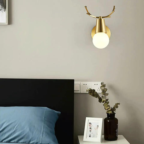 Brass Antlers Wall Sconce With E27 Socket Creates A Cozy Top Tier Glow For Bedrooms And Living Rooms Featuring Easy Peasy Install Vibes. Stylish lamp mounted beside a bed.