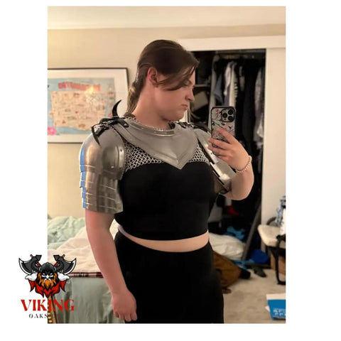 Person wearing Gothic Steel Gorget With Pauldrons Shoulder Guard Set For LARP And SCA Knights, silver medieval armor, indoors.