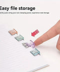 Hand using 20 Pairs Quick Fix Hem Clips and Reusable Clamps for Pants, Paper and Window Ventilation, Transparent Purple Tops