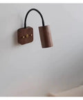 Modern Walnut Wall Sconce With 360 Degree Swivel Spotlight Brings Chill Vibes To Bedrooms And Living Rooms While Delivering Smooth Adjustments For Aisles That Makes Installation A Breeze Today, featuring a cylindrical light on a wooden base.