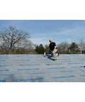 Top Shelf Synthetic Roof Underlayment Roll Heavy Duty Water Blocked Roofing Felt Alternative With Tough Woven Core For Clean Smooth Decks And Long Lasting Ultraviolet Protection Coverage installed on a flat roof with a worker.
