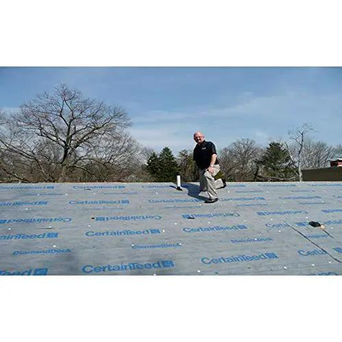 Top Shelf Synthetic Roof Underlayment Roll Heavy Duty Water Blocked Roofing Felt Alternative With Tough Woven Core For Clean Smooth Decks And Long Lasting Ultraviolet Protection Coverage installed on a flat roof with a worker.