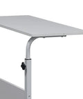 Adjustable standing computer desk featuring smooth locking wheels and foldable design for cozy living room setups.