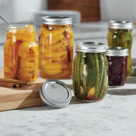 Real Deal Wide Mouth Glass Mason Jars With Lids And Bands For Canning And Pickling Quart 32 Oz Pack Of 2 filled with preserves and veggies.