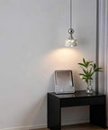 Terrazzo Small Pendant Light, 4.7 Inch Chrome Hanging Fixture illuminating a side table with a plant and tray.