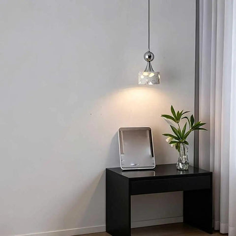 Terrazzo Small Pendant Light, 4.7 Inch Chrome Hanging Fixture illuminating a side table with a plant and tray.