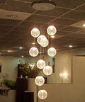Top Tier Modern Chandelier With Round Glass Globes And Sleek Metal Frame Delivers A Heck Of A Statement For Staircases Or Spacious Living Rooms Featuring Easy Screw In Bulbs That Instantly Dial Up The Home Vibes, showcasing hanging round glass globes.