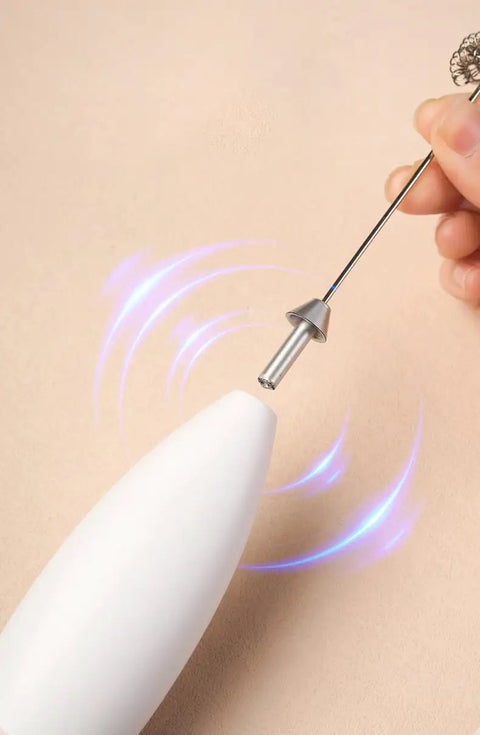 Handheld frother in use, with stainless steel whisk and white body, ideal for crafting silky foam for drinks.