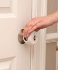 Hand installing Grip N Twist cover from Home Safety Essentials Kit For Kids With 46 Pieces Including Door Knob Covers And Cabinet Latches White Finish