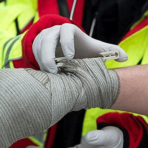 Rhino Rescue 6-inch Israeli style emergency bandage being applied to forearm; white sterile wrap with closure tab