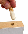 Hand inserting fluted birch dowel pin with glue into board for joinery, part of Birch Dowel Pins 1/4 In x 1-1/8 In 200-Pack.