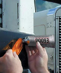 Applying Hi Visc 3.7-Ounce Adhesive Go-To Bond on vehicle light for tough projects; ensures strong, flexible bond on metal surface.