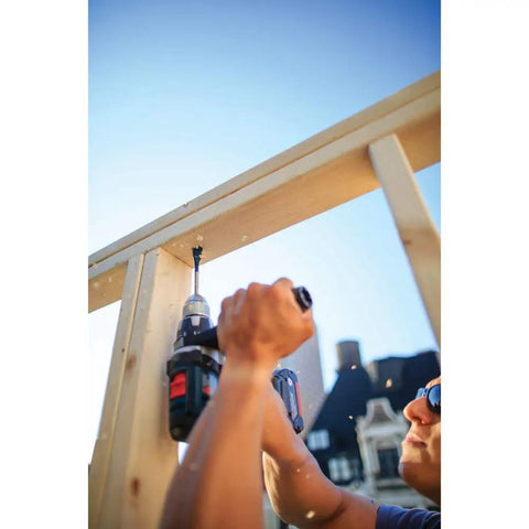 Person using 12 Piece Daredevil Spade Bit Set With One Quarter Inch Hex Shank For Fast Wood Drilling on a wooden structure outdoors.