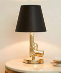 Gold Gun Desk Light With Linen Shade, Modern Pistol Style Desk Lamp, on table with black shade, Nordic Metal Craft, side view