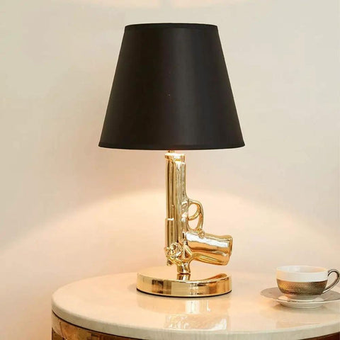 Gold Gun Desk Light With Linen Shade, Modern Pistol Style Desk Lamp, on table with black shade, Nordic Metal Craft, side view
