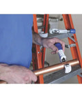 Person using Tube Cutter 1/8 To 1-3/4 Inch With Full Stop Feed System Keeps Wheels From Contact on copper pipe near orange ladder.
