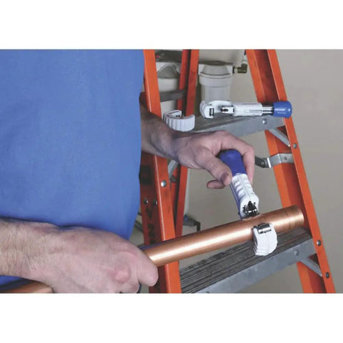 Person using Tube Cutter 1/8 To 1-3/4 Inch With Full Stop Feed System Keeps Wheels From Contact on copper pipe near orange ladder.
