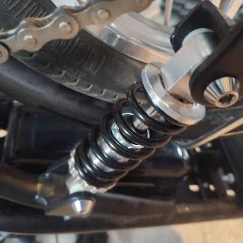 Close-up of 215mm universal rear shock absorber on bike fitting dirt bikes, ATVs for a bump-free ride on rough trails