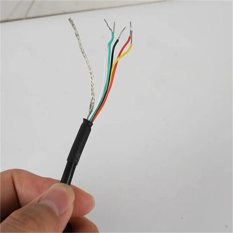 Hand holding exposed wires of Rotary Encoder TRD-GK1000-RZ 600 360 1024 2000 Incremental Encoder for Precision Motion Control.