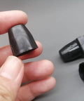 Close-up of hand holding a 15mm black plastic dust cover, part of 8 Pack Fifteen Millimeter Bike Hub Axle Dust Covers Replacement End Caps.