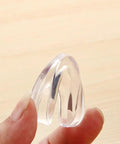 Clear corner protector for tables held by hand, part of 30 Pcs Table Corner Protectors With Heavy Duty Adhesive Tape Soft PVC Safety Corner Guards For Anti Collision