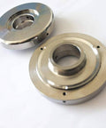 Two chrome bushing retainer flanges with center bore and mounting holes