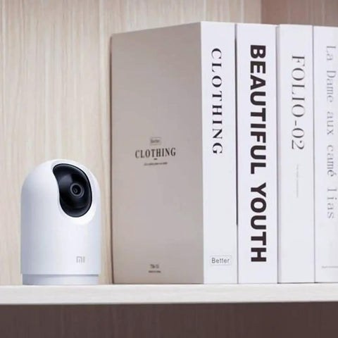 2K Pro PTZ Home Security Camera With 360 Degree Panorama WiFi Dual Band AI Human Detection Full Color Night Vision In Low Light Upgraded 3 Million Pixel Sensor displayed on a shelf next to books