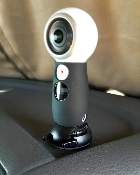 Quick Release Flat And Curved Surface Camera Mount With Strong Adhesive Base holds a camera on a dashboard surface.