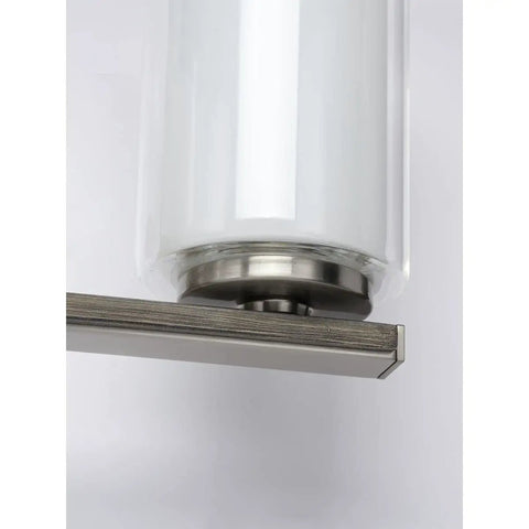 Close-up of Four Light Linear Chandelier in Brushed Nickel with faux wood back plate and clear glass shade detail