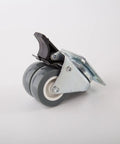 Heavy Duty Twin Caster Wheels with Plate for Furniture Carts showing dual gray wheels and locking mechanism from a side angle.