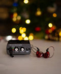 S1 Personal In-Ear Monitor Headphone Amplifier displayed with red earphones, festive background, compact IEM system