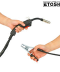 Hands holding welding gun and ground clamp of Flux Core MIG Welder 160A Portable Gasless Wire Feed Machine For 110V Home DIY Projects