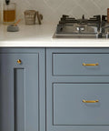 Kitchen with blue cabinets featuring Six Pack Champagne Bronze Cabinet Pulls 3 Inch Hole Center Solid Zinc Alloy Dresser Drawer Handles.