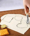 Front view of a 1.3-inch fluted pastry wheel with wooden handle cutting dough into circle, heart, and square shapes.