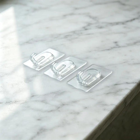 Upgraded Heavy Duty Nano Acrylic Gel Small Clear Adhesive Hooks 36 Pack Damage Free Mini Wall Hangers arranged on marble surface.