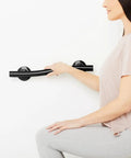 Person using 18 Inch Designer Wave Shower Grab Bar In Matte Black for support, highlighting sleek design and modern bath safety rail